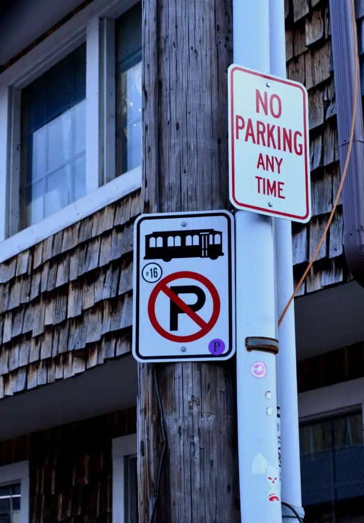 No Parking Any Time sign mounted on a utility pole beside a residential building
