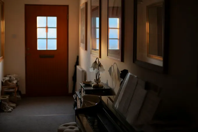 Movers guiding a piano through a home entry