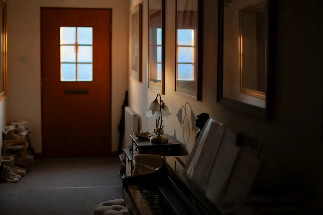 Movers guiding a piano through a home entry