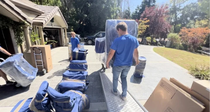 Movers carefully relocating furniture from a large family home