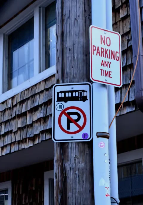 No Parking Any Time sign mounted on a utility pole beside a residential building
