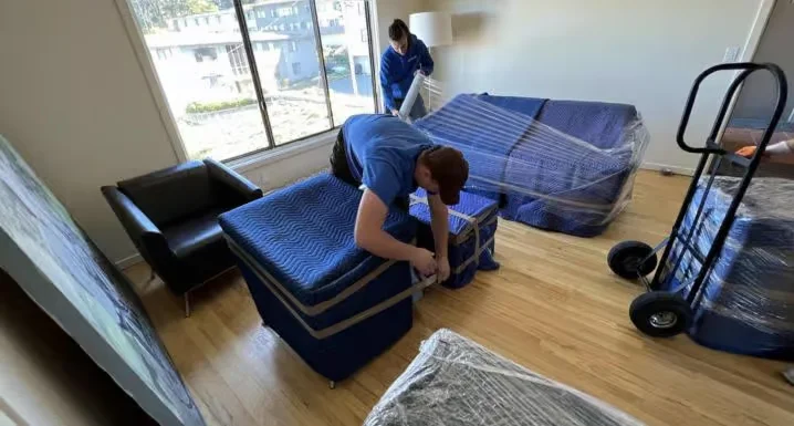 ShipShape Moving crew wrapping and padding furniture to protect it during a move