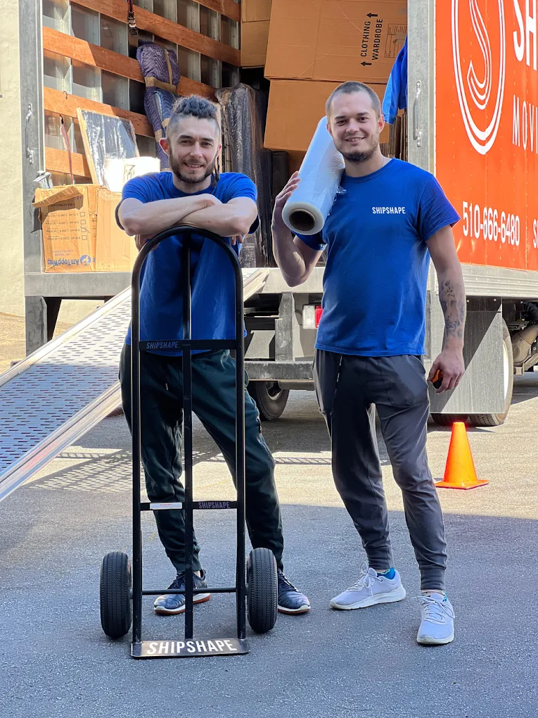 ShipShape Moving team members standing with equipment beside a moving truck